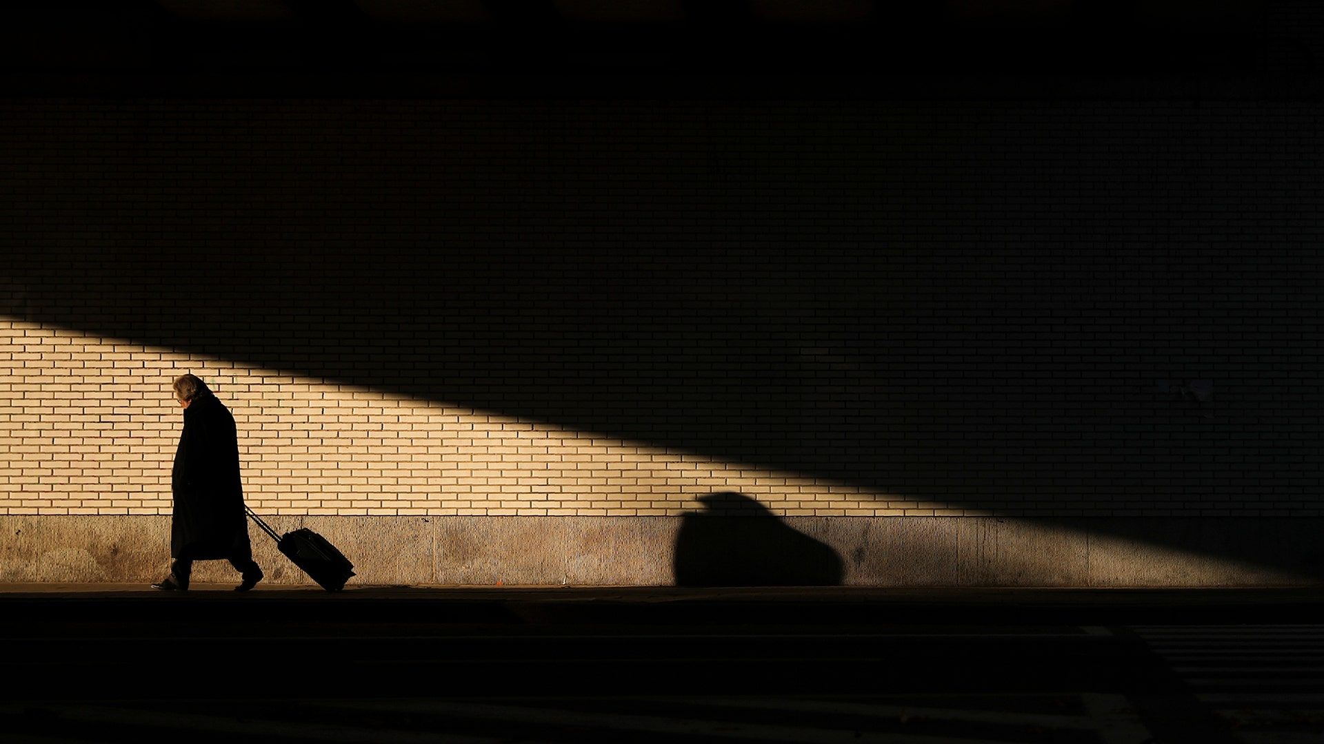 A man pulls a trolley as he walks under a bridge in Brussels, Nov. 20, 2019. 