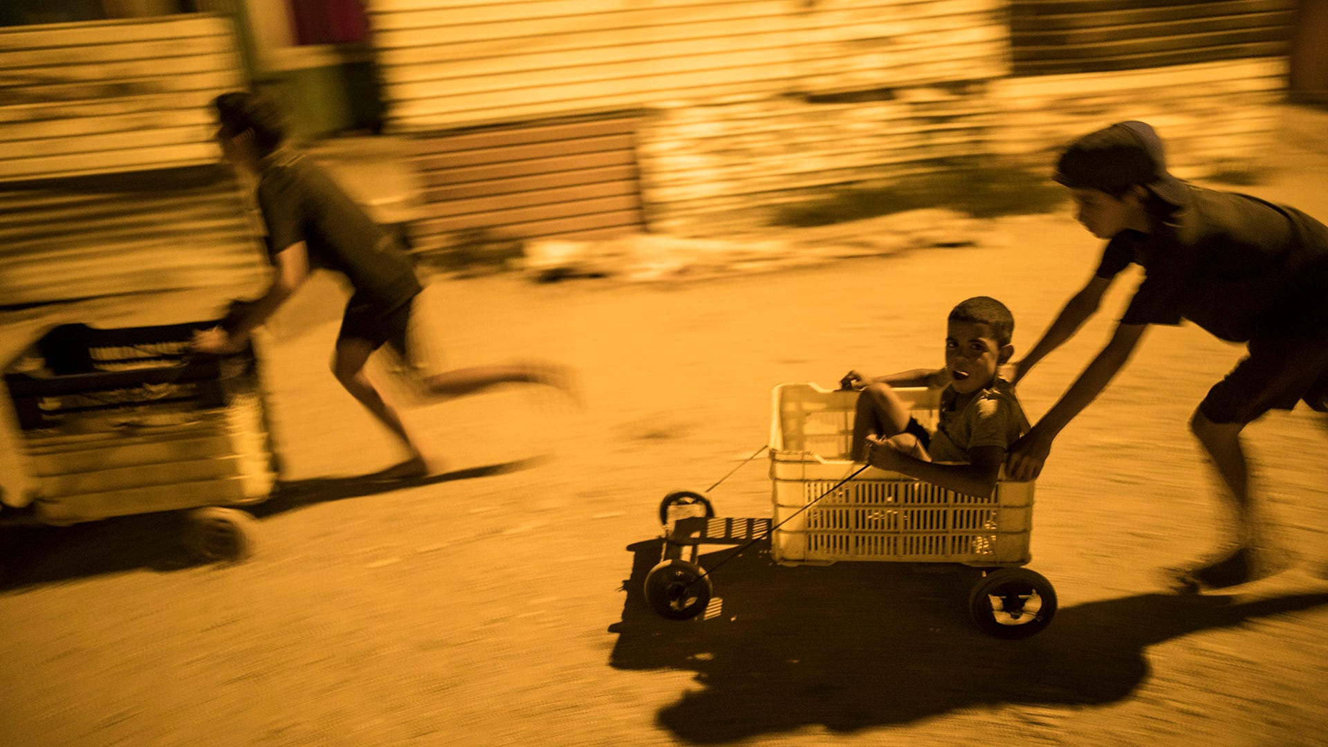 Children race in makeshift go-carts in the "Altos de Milagros Norte" neighborhood of Maracaibo, Venezuela, Nov. 19, 2019. 