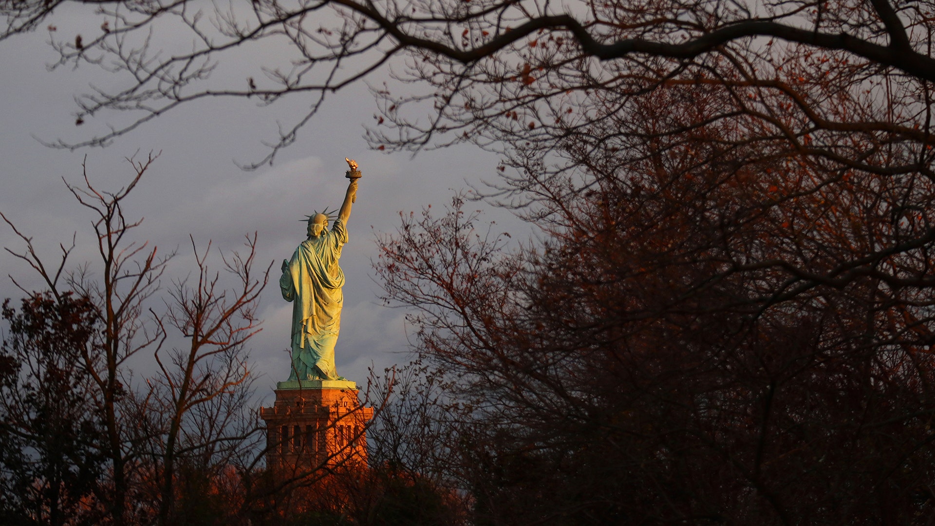 The sun sets on the Statue of Liberty in New York City, Nov. 24, 2019.