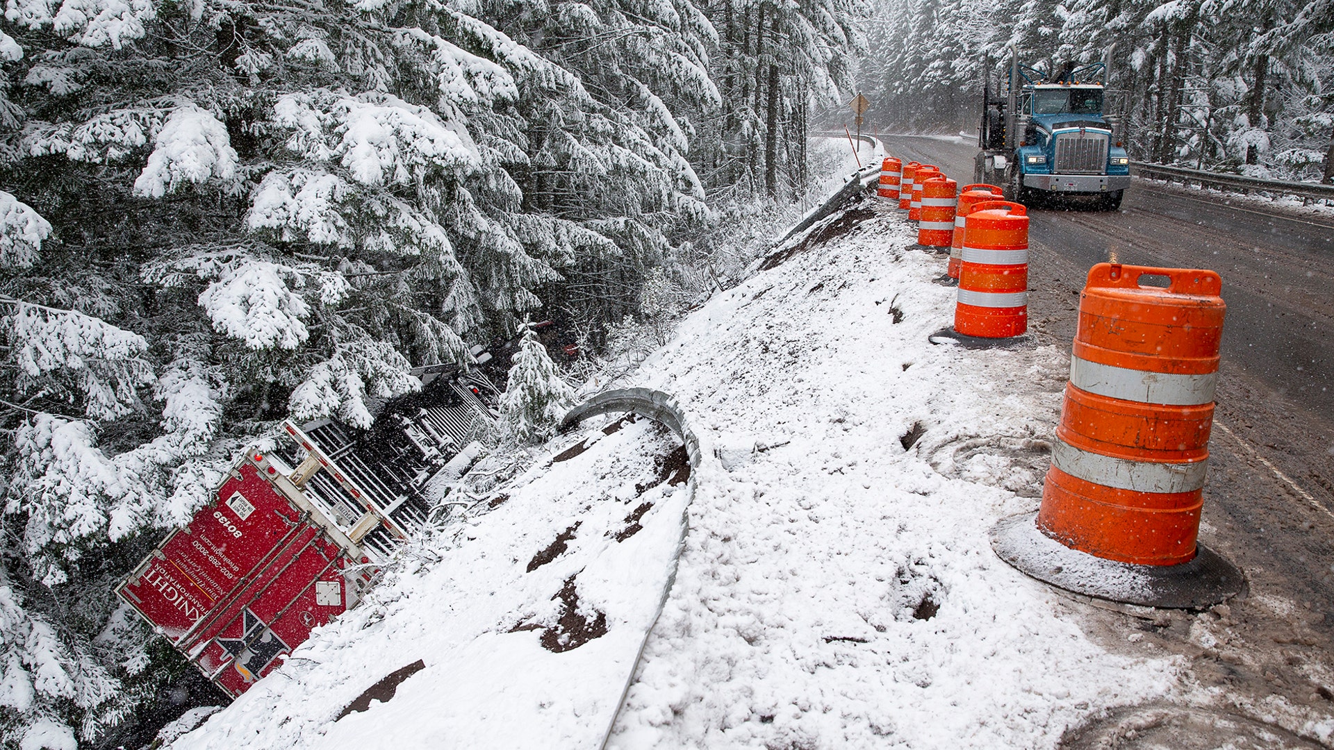 A tractor-trailer rests upside down after it left Highway 58 under snowy conditions east of Oakridge, Ore., Nov. 25, 2019.