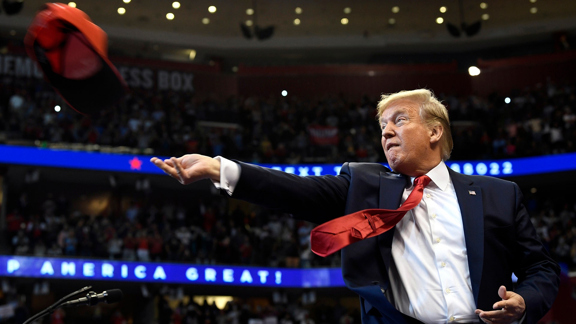 President Donald Trump throws a hat as he arrives to speak at a campaign rally in Sunrise, Fla., Nov. 26, 2019.