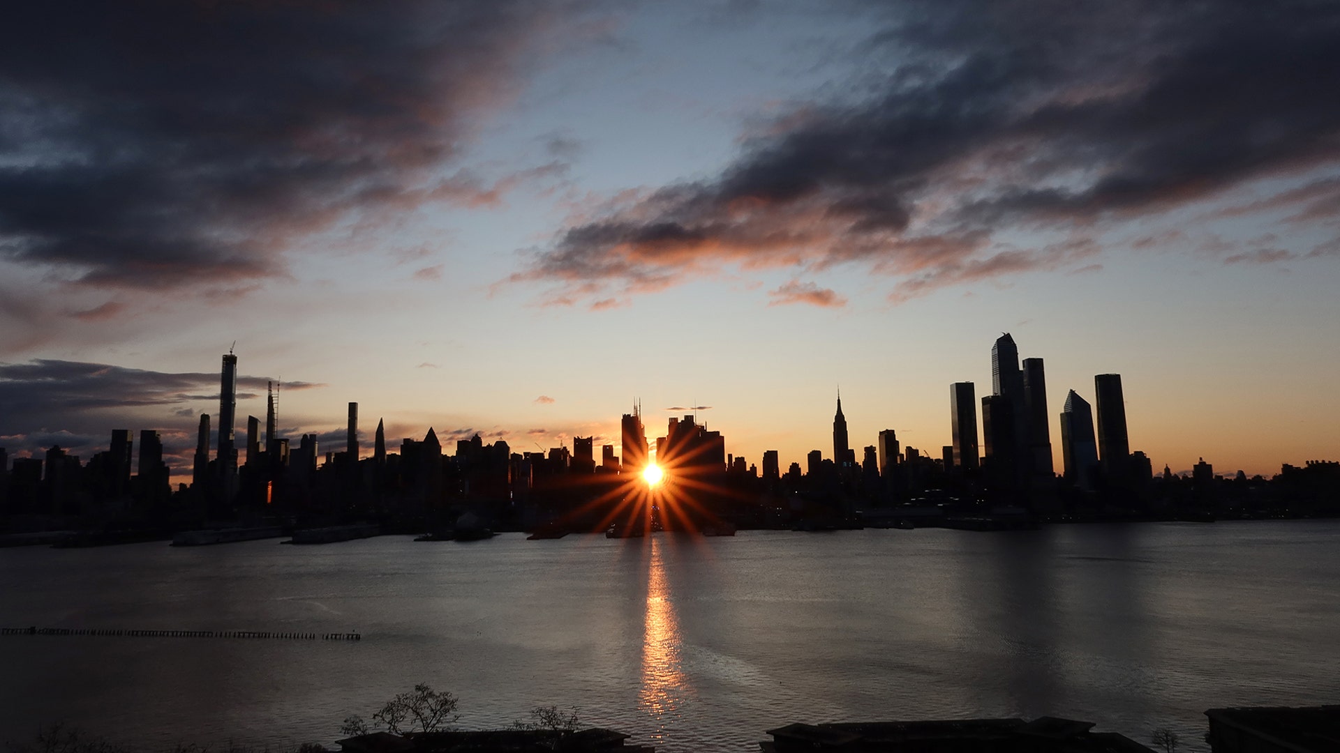 The sun rises down 42nd Street behind the skyline of midtown Manhattan and the Empire State Building in New York City, Nov. 28, 2019.