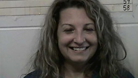 Oklahoma woman, 48, smiles in mugshot after arrest in husband's stabbing death