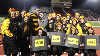 Texas cheerleading squad helps man propose to coach during game