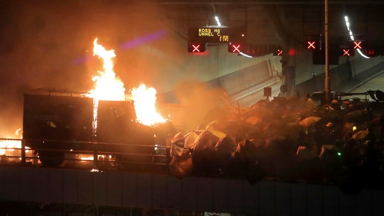 Hong Kong police officer shot with arrow, protesters set fires as Chinese troops appear to clean streets