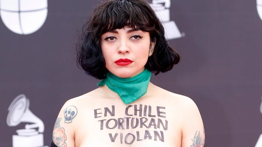 Chilean singer protests topless at Latin Grammys as government bows to referendum demands