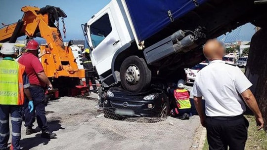 South African woman survives after truck rolls down hill and lands on her car, trapping her