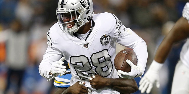 Oakland Raiders running back Josh Jacobs (28) tries to get away from Los Angeles Chargers defensive end Melvin Ingram III during the first half of an NFL football game in Oakland, Calif., Thursday, Nov. 7, 2019. (AP Photo/D. Ross Cameron)