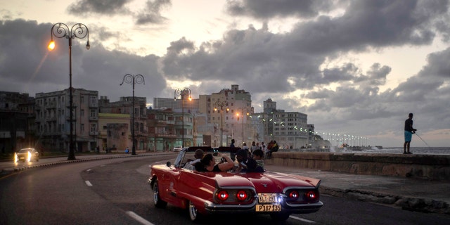 In this Nov. 10, 2019, photo, tourists take a joy ride along the malecon sea wall in Havana, Cuba. The city of Havana celebrated its 500th anniversary on Nov. 16. (AP Photo/Ramon Espinosa)