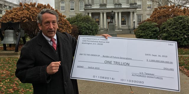 Mark Sanford holds up a fake check as he bows out of the presidential race, in New Hampshire. (Paul Steinhauser)