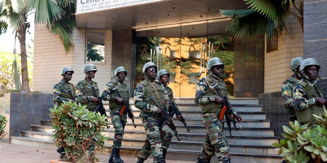 In this Saturday, Nov. 21, 2015 file photo, soldiers from the presidential guard patrol outside the Radisson Blu hotel in Bamako after it was attacked by Islamic extremists armed with guns and grenades.