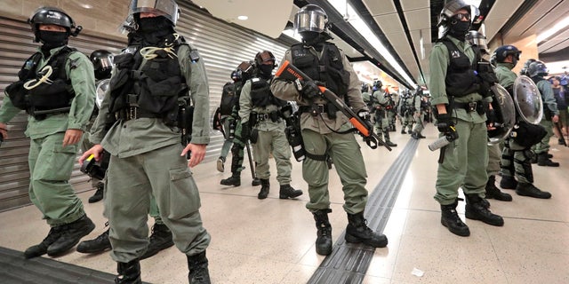 Riot police form a line at a shopping mall in Hong Kong, Sunday, Nov. 3, 2019. Riot police stormed several malls in Hong Kong on Sunday in a move to thwart more pro-democracy protests, as the city's leader heads to Beijing for talks on deepening economic integration between the semi-autonomous Chinese territory and mainland China. (AP Photo/Dita Alangkara)