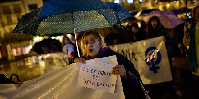 A woman holds a sign reading ''It is not abuse, it is rape'' as people gather at Plaza del Castillo square to a protest against sexual assault, in Pamplona, northern Spain, Monday, Nov. 4, 2019. (AP Photo/Alvaro Barrientos)