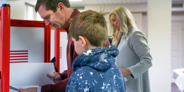 Kentucky Attorney General and Democratic Gubernatorial candidate Andy Beshear studies his ballot at the Knights of Columbus polling location Tuesday, Nov. 5, 2019, in Louisville, Ky. Kentucky's voters are now deciding the political grudge match between Republican Gov. Matt Bevin and Beshear. (AP Photo/Bryan Woolston)