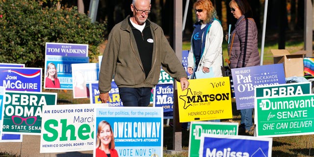 Voters walk through a sea of campaign signs at a polling station in Richmond, Va., Tuesday, Nov. 5, 2019. All seats in the Virginia House of Delegates and State senate are up for election. (AP Photo/Steve Helber)