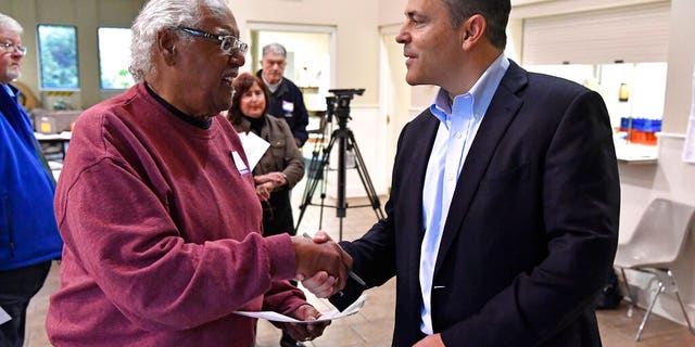 Kentucky Governor and Republican gubernatorial candidate Matt Bevin, right, shakes hands with a poll worker after casting his ballot in the state's general election in Louisville, Ky., Tuesday, Nov. 5, 2019. (AP Photo/Timothy D. Easley)