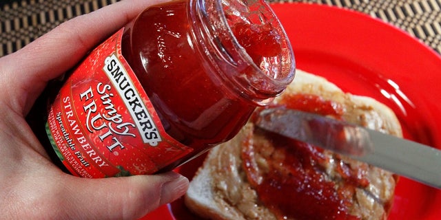 In this Feb. 14, 2011 file photo, Smucker's Simply Fruit Strawberry is spread atop peanut butter in Pittsburgh. Anyone with unpaid parking fines at the University of Alaska, Anchorage campus has the option to reduce or cover the cost of their tickets with peanut butter and jelly. KTUU-TV reported the university would take donations for their annual payment tradition until Nov. 8 to help combat student hunger. Officials say the food goes to students in need. (AP Photo/Gene J. Puskar, File)