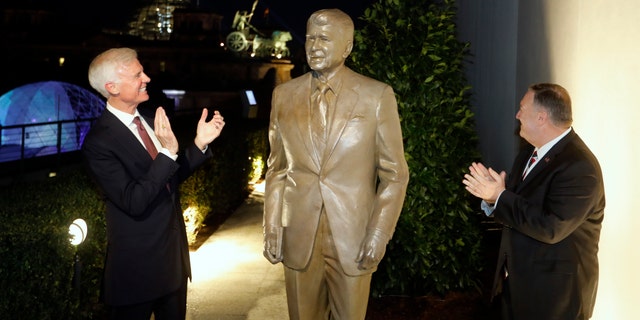 Together with United States Ambassador in Germany Richard Grenell, right, and Fred Ryan Board Chairman of the Reagan Foundation, left, Secretary of State Mike Pompeo unveils a statue of former President Ronald Reagan on the top of United States embassy in Berlin, Germany, Friday, Nov. 7, 2019. 