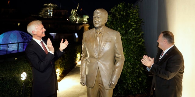 Together with United States Ambassador in Germany Richard Grenell, right, and Fred Ryan Board Chairman of the Reagan Foundation, left, Secretary of State Mike Pompeo unveils a statue of former President Ronald Reagan on the top of United States embassy in Berlin, Germany, Friday, Nov. 7, 2019.