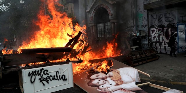 Items removed from a church by anti-government protesters go up in flames in a barricade built by the protesters in Santiago, Chile on Friday. (AP Photo/Esteban Felix)