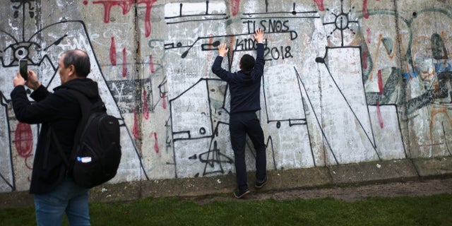 Tourist take photos at remains of the Berlin Wall after commemorations celebrating the 30th anniversary of the fall of the Berlin Wall at the Wall memorial site at Bernauer Strasse in Berlin, Saturday, Nov. 9, 2019. 