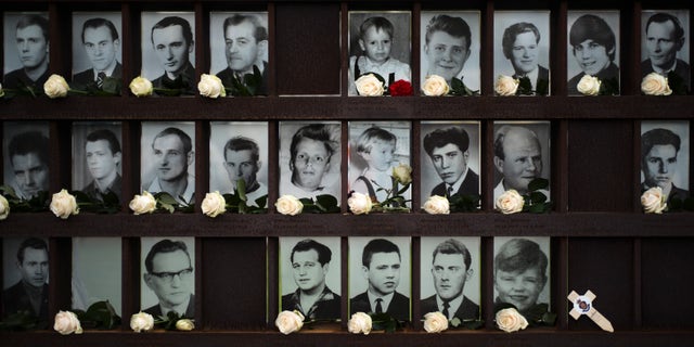 Flowers dropped in front of portraits from people died at the Berlin wall after commemorations celebrating the 30th anniversary of the fall of the Berlin Wall at the Wall memorial site at Bernauer Strasse in Berlin, Saturday, Nov. 9, 2019.