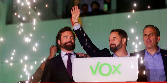 Santiago Abascal, leader of far-right Vox Party, waves to supporters as fireworks go off outside the party headquarters after the announcement of the general election first results, in Madrid.