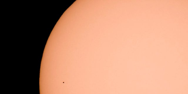 The planet Mercury transits across the face of the Sun, as seen from Kekesteto, Hungary's highest mountain peak on Monday. Stargazers used solar filtered binoculars and telescopes to spot Mercury, the solar system's smallest, innermost planet, as a tiny black dot as it passed between Earth and the sun on Monday. (Peter Komka/MTI via AP)