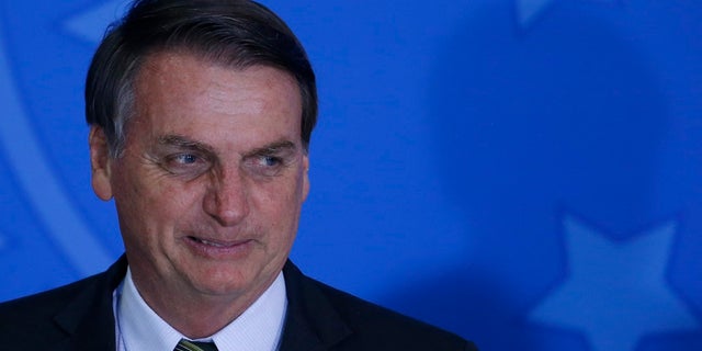 Brazil's President Jair Bolsonaro attends the launch of the Green and Yellow program to create formal jobs for young people earlier this month. (AP Photo/Eraldo Peres)
