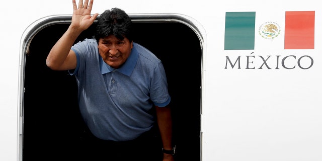 Morales waves upon arrival to Mexico City, Tuesday, Nov. 12, 2019. (AP Photo/Eduardo Verdugo)