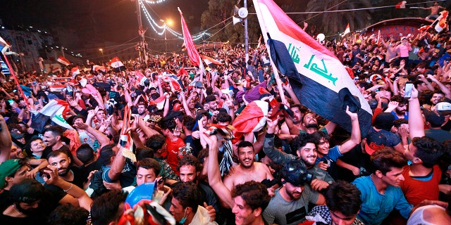 Anti-government protesters celebrate a soccer match win in Tahrir Square in Baghdad, Iraq, Thursday, Nov. 14, 2019. Iraqis are celebrating a 2-1 win over Iran in a much-anticipated World Cup qualifying match. (AP Photo/Hadi Mizban)