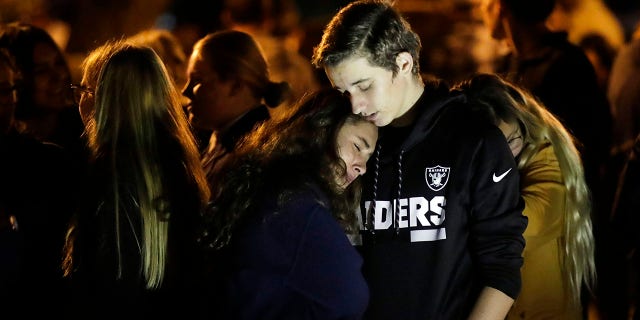 Hannah Schooping-Gutierrez, center, a student at Saugus High School, is comforted by her boyfriend Declan Sheridan, at right, a student at nearby Valencia High School during a vigil at Central Park in the aftermath of a shooting at Saugus Thursday, Nov. 14, 2019, in Santa Clarita, Calif. (AP Photo/Marcio Jose Sanchez)