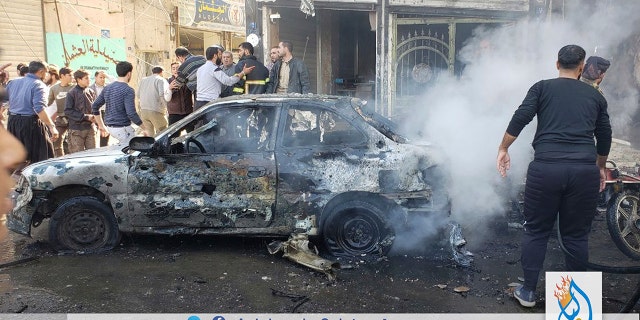 This photo provided by the Syrian anti-government activist group Albab City, which has been authenticated based on its contents and other AP reporting, people check the aftermath of a car bomb exploded in the city of al-Bab, northern Syria, Saturday, Nov. 16, 2019. (Albab City via AP)