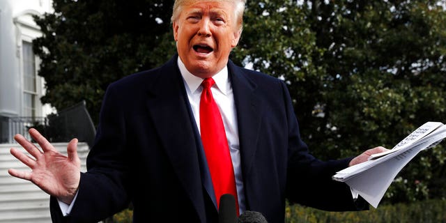 President Donald Trump holds handwritten notes as he speaks to the media about the House Intelligence Committee testimony of U.S. Ambassador to the European Union Gordon Sondland, Wednesday, Nov. 20, 2019, as Trump leaves the White House in Washington, en route to Texas. (AP Photo/Jacquelyn Martin)