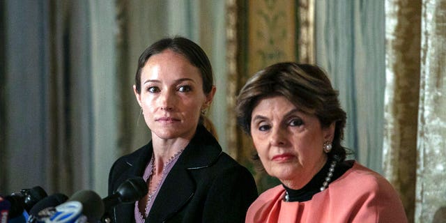 Teala Davies, left, and attorney Gloria Allred, right, at a news conference about the filing of a lawsuit against the estate of Jeffrey Epstein. Davies said she was 17 when he victimized her. (AP Photo/Jeenah Moon)