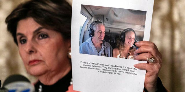 Attorney Gloria Allred, holds a picture of Jeffrey Epstein and her client Teala Davis during a news conference, Thursday, Nov. 21, 2019, in New York, about the filing of a lawsuit against the estate of Epstein. Davies says she was 17 when she was victimized by Epstein.