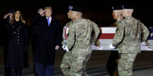 President Donald Trump and first lady Melania Trump watch as a U.S. Army carry team moves a transfer case containing the remains of Chief Warrant Officer 2 David C. Knadle, of Tarrant, Texas, Thursday, Nov. 21, 2019, at Dover Air Force Base, Del. According to the Department of Defense, Knadle died in Afghanistan when his helicopter crashed while providing security for troops on the ground in eastern Logar Province. (AP Photo/ Evan Vucci)