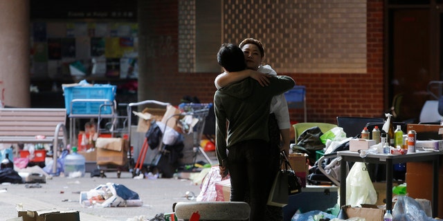 A protester hugs a social worker inside the campus of Hong Kong Polytechnic University in Hong Kong Friday, Nov. 22, 2019. Most of the protesters who took over the university last week have left, but an unknown number have remained inside for days, hoping somehow to avoid arrest. (AP Photo/Achmad Ibrahim)