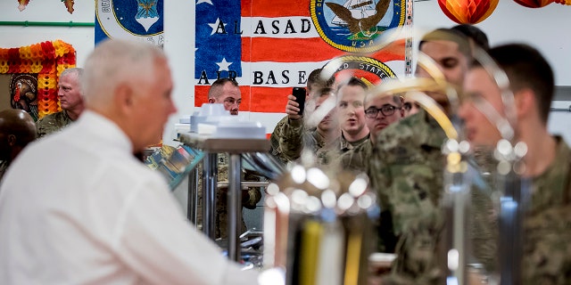 Vice President Mike Pence, foreground left, serves turkey to troops at Al Asad Air Base, Iraq, Saturday, Nov. 23, 2019. (AP Photo/Andrew Harnik)