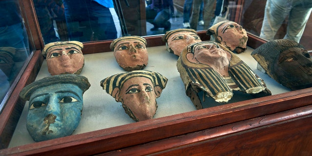 Wooden and clay mummies masks are displayed in Saqqara, south Giza, Egypt. Saturday, Nov. 23, 2019. The new discovery was displayed at a makeshift exhibition at the famed Step Pyramid of Djoser in Saqqara, south of Cairo, near the mummies and other artifacts were found in a vast necropolis. (AP Photo/Hamada Elrasam)