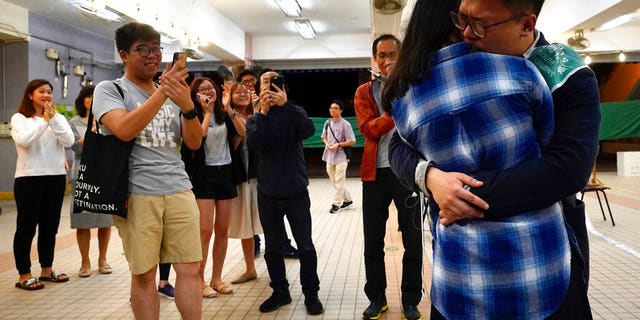 Pro-democracy candidate James Yu hugging his girlfriend after winning his seat in district council elections in Hong Kong, early Monday. (AP Photo/Vincent Yu)