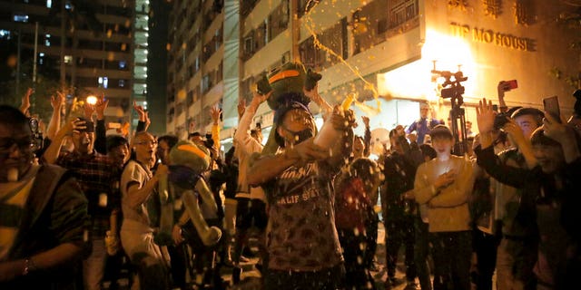 Pro-democracy supporters celebrating after pro-Beijing politician Junius Ho lost his election in Hong Kong, early Monday. (AP Photo/Kin Cheung)