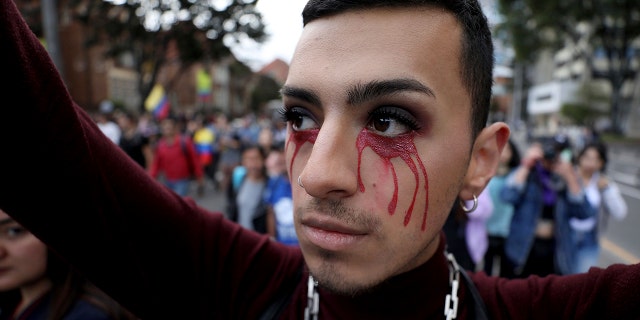 An anti-government demonstrator with red tears painted on his face joins protest in Bogota, Colombia, Monday, Nov. 25, 2019. (AP Photo/Fernando Vergara)