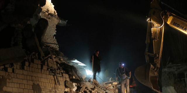 Rescuers search a collapsed building after a magnitude 6.4 earthquake in Thumane, western Albania, Tuesday, Nov. 26, 2019. Rescue crews with excavators searched for survivors trapped in toppled apartment buildings and hotels Tuesday after a powerful pre-dawn earthquake in Albania killed at least 18 people and injured more than 600. (AP Photo/Visar Kryeziu)