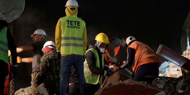 Rescuers search at a collapsed building after a magnitude 6.4 earthquake in Thumane, western Albania, Tuesday, Nov. 26, 2019. Rescue crews with excavators searched for survivors trapped in toppled apartment buildings and hotels Tuesday after a powerful pre-dawn earthquake in Albania killed at least 18 people and injured more than 600. (AP Photo/Visar Kryeziu)