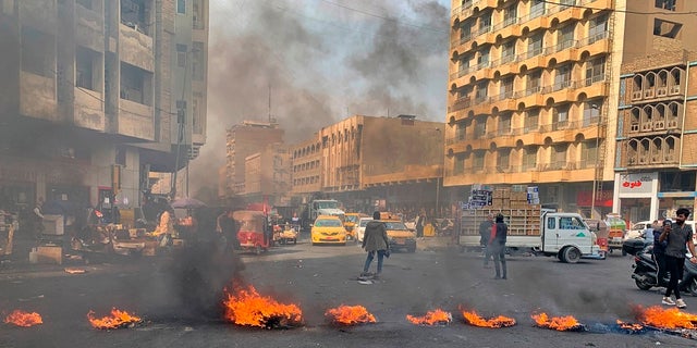 Anti-government protesters set fire to block streets during ongoing protests in Baghdad on Wednesday. (AP Photo/Ali Abdul Hassan)