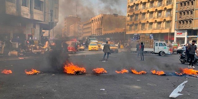 Political News: Anti-government protesters set fire to block streets during ongoing protests in Baghdad Wednesday. (AP Photo/Ali Abdul Hassan)
