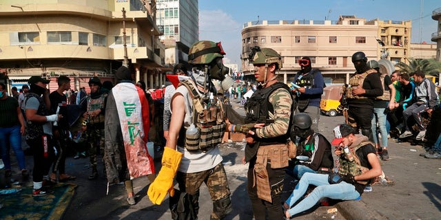 Anti-government protesters gather on Rasheed Street in Baghdad, Iraq, on Wednesday. Several protesters were killed by security forces who fired live rounds in Baghdad and southern Iraq amid ongoing violence and days of sit-ins and road closures, Iraqi officials said Wednesday. (AP Photo/Khalid Mohammed)