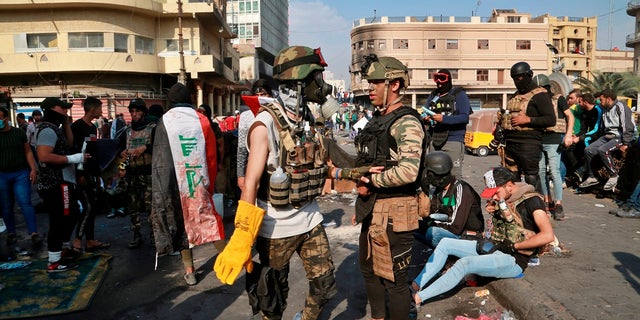Anti-government protesters gather on Rasheed Street in Baghdad, Iraq, on Wednesday. Several protesters were killed by security forces who fired live rounds in Baghdad and southern Iraq amid ongoing violence and days of sit-ins and road closures, Iraqi officials said Wednesday. (AP Photo/Khalid Mohammed)