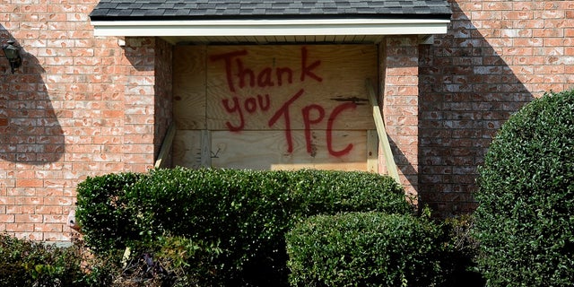 A boarded up window bears a message for TPC Group as residents and business owners throughout Port Neches, Texas clean up from the damage caused by an explosion on Wednesday. Three workers were injured early Wednesday in a massive explosion at the Texas chemical plant that also blew out the windows and doors of nearby homes. (Kim Brent/The Beaumont Enterprise via AP)